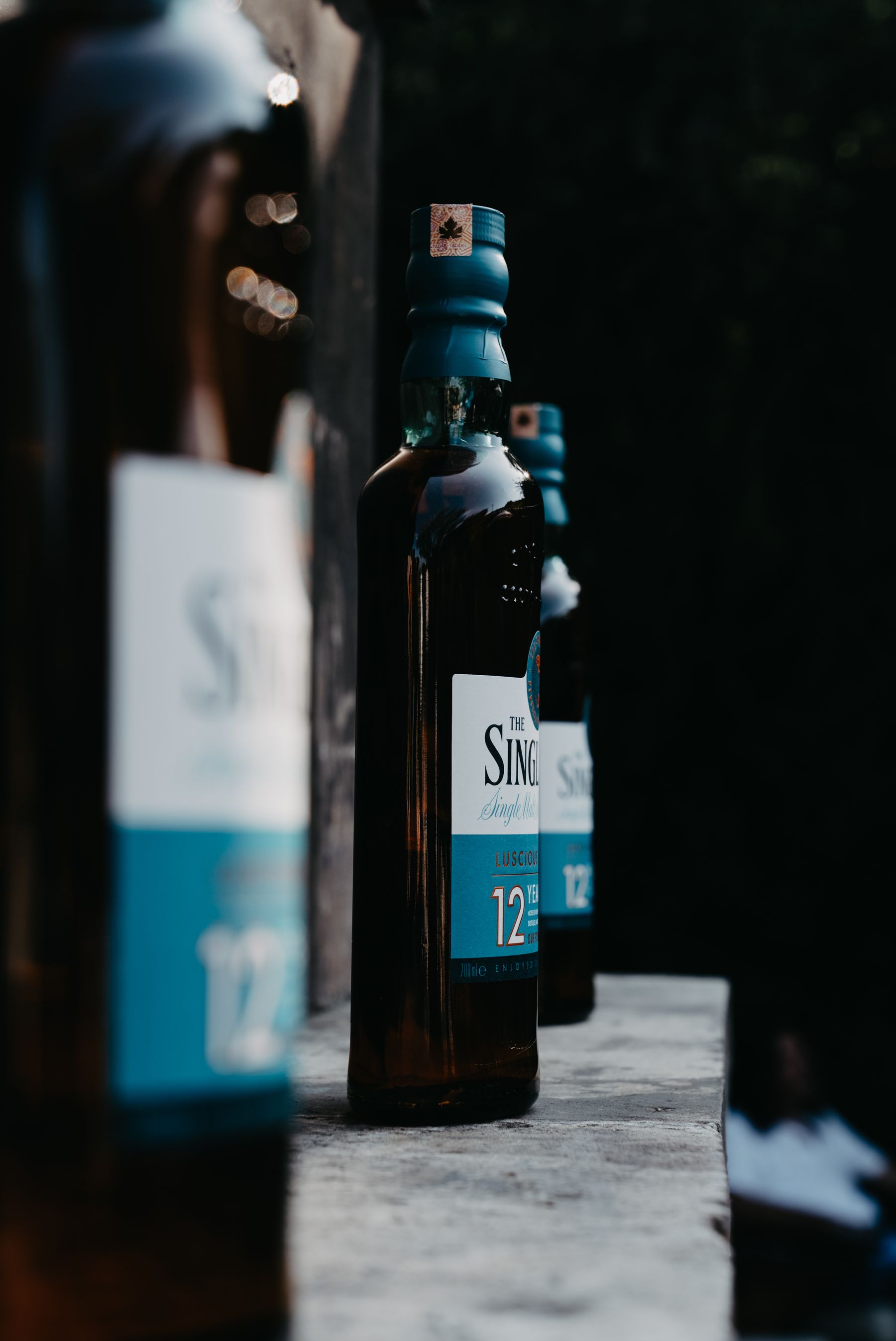 A close view of whisky bottles in subdued bar light