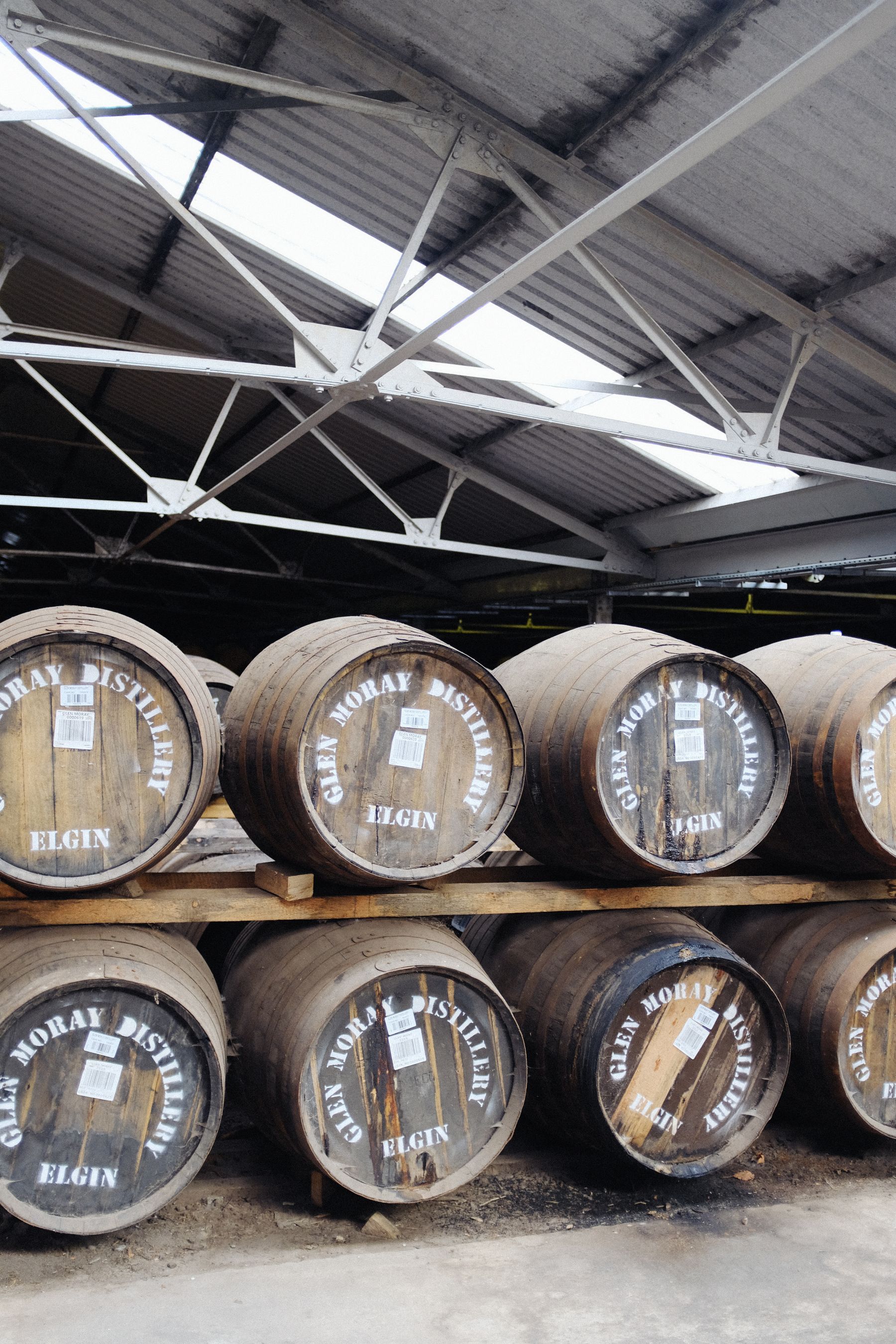 Rows of Scotch whisky casks resting in an Elgin warehouse