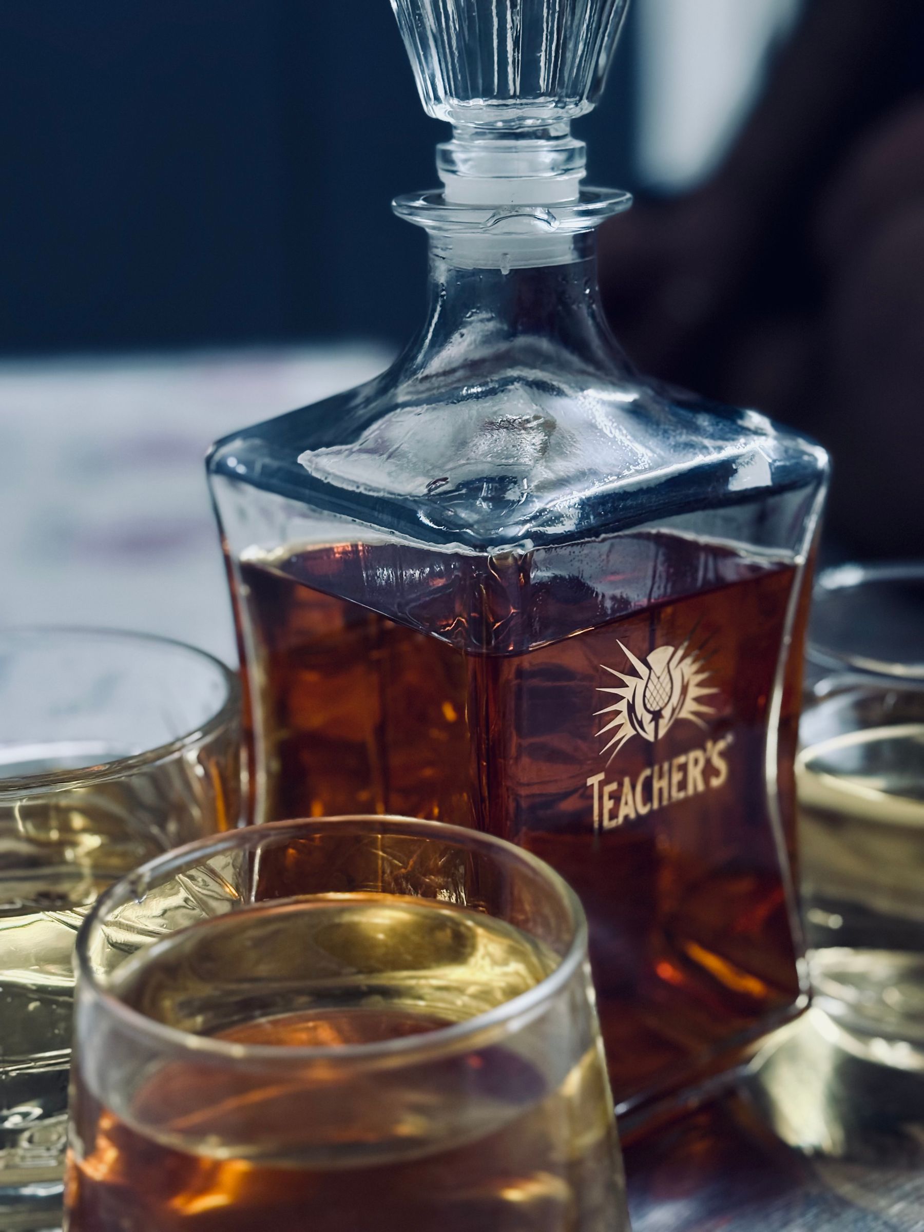 Whisky decanter and glasses arranged in subdued light