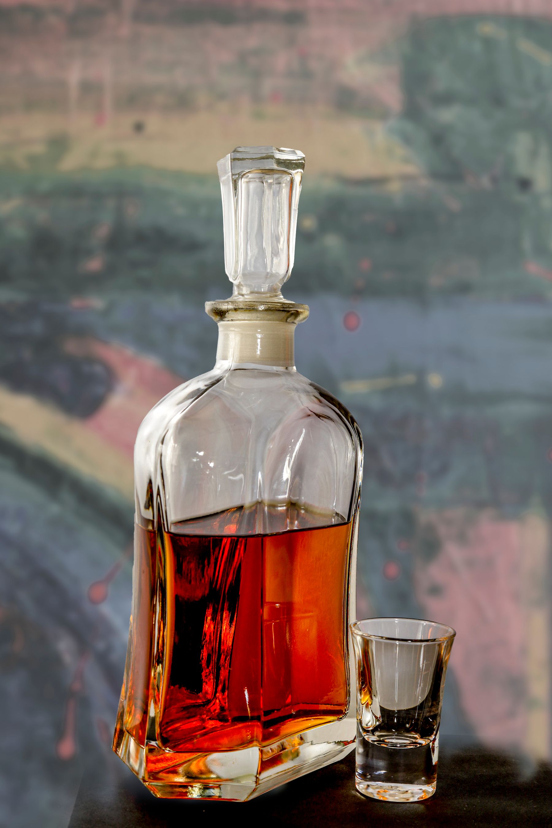 A sculptural crystal decanter and glass in abstract light