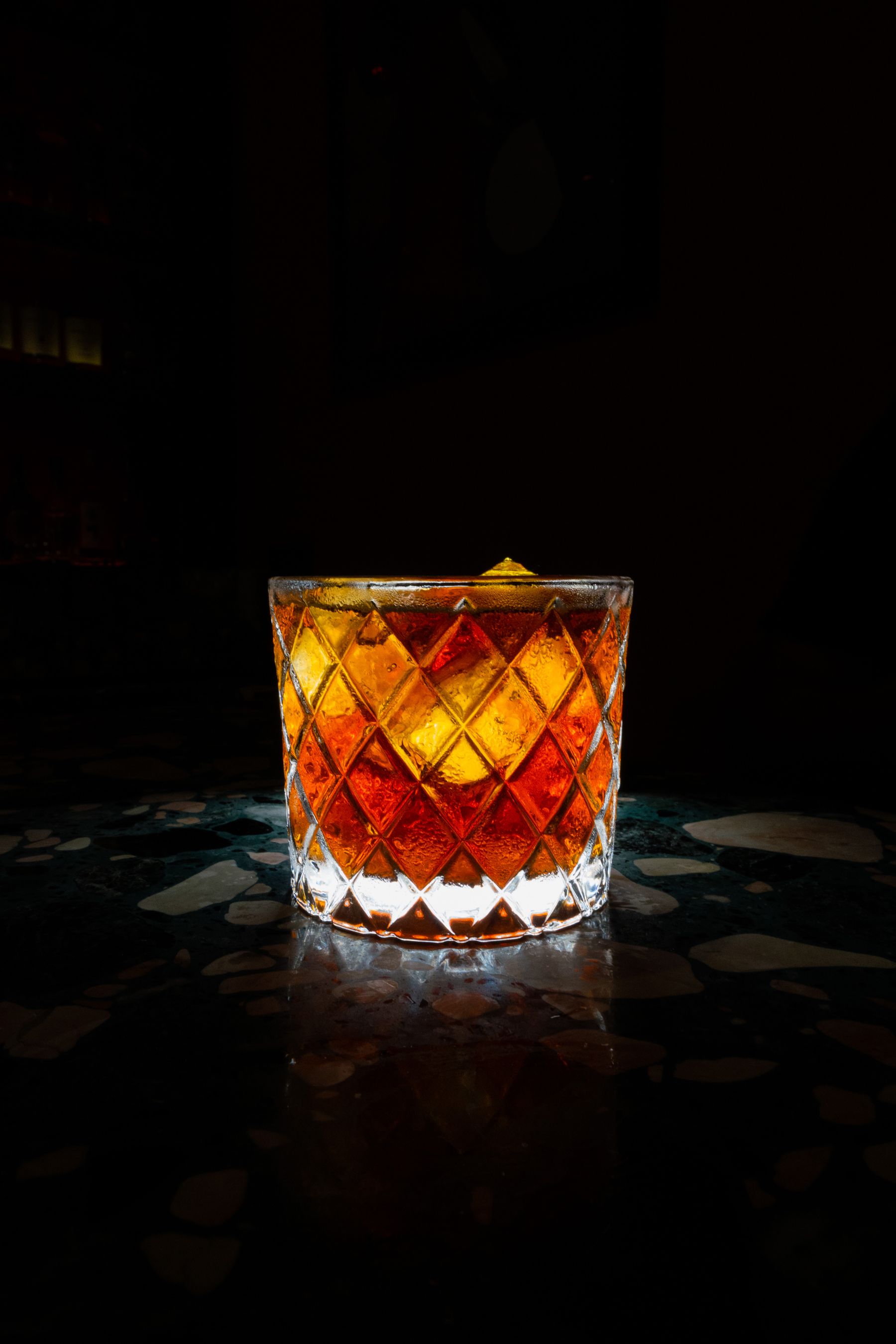An amber whisky cocktail in a cut crystal glass